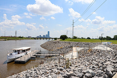 Oklahoma River Cruise boat docked at the Stockyards Landing with Downtown Oklahoma City Skyline in the background in summer.