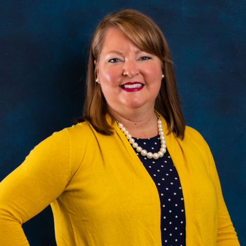 Headshot of Senior Project Manager Kristen Torkelson with blue background.